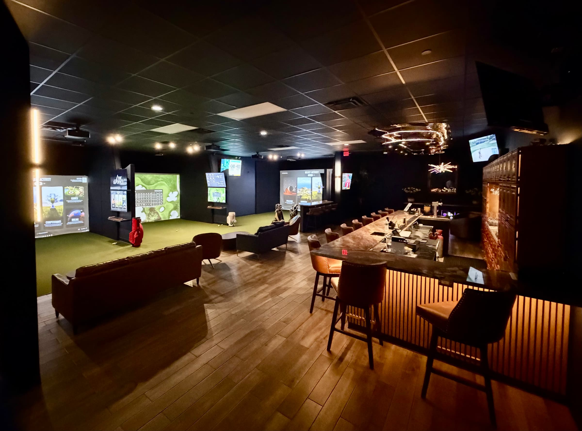 The Office private indoor golf club lounge with TrackMan simulator bays and bar in North Palm Beach